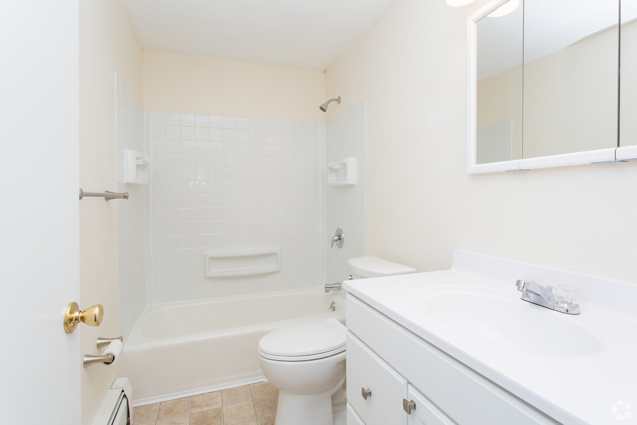 A bathroom with white fixtures and a toilet.